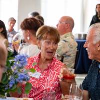 Ann Villemure sitting at table, talking with gentleman sitting next to her